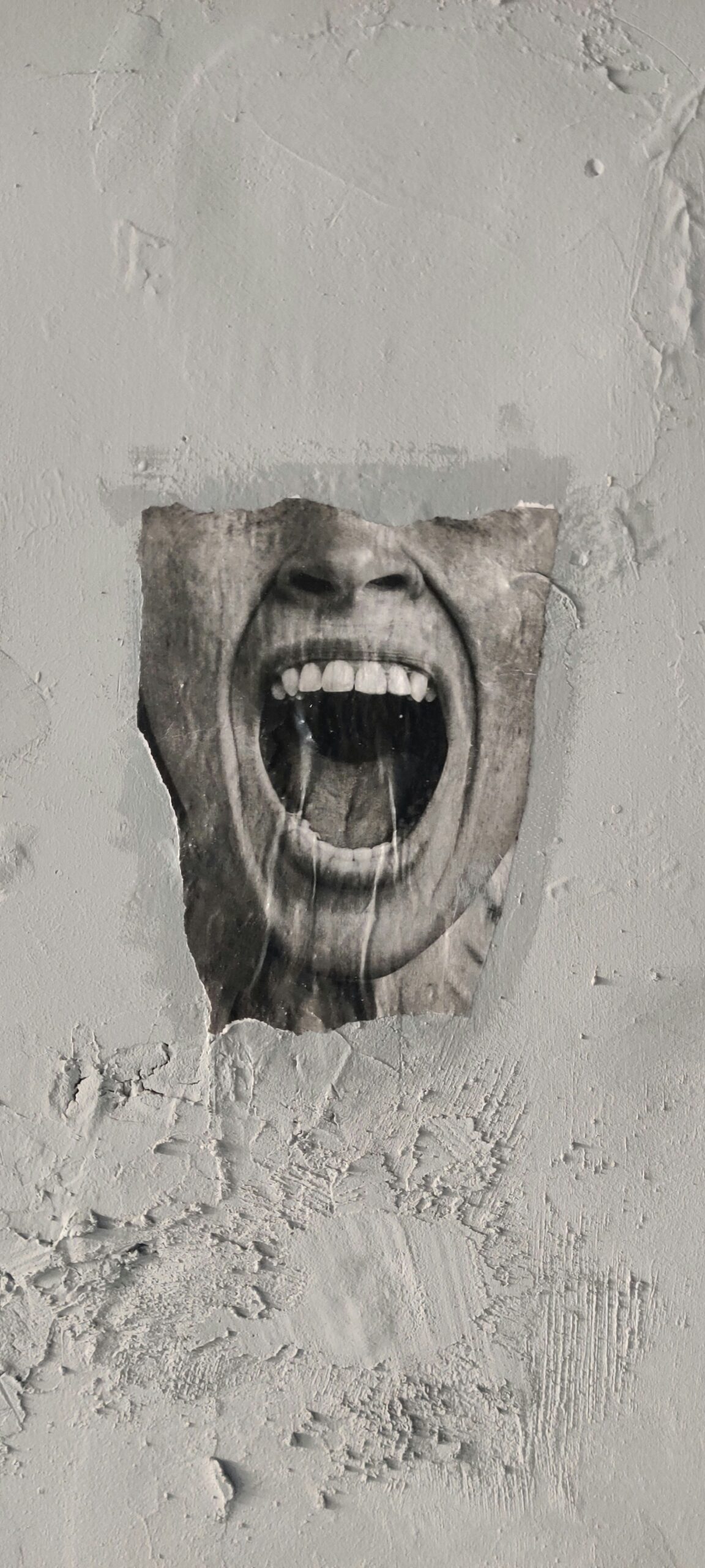 Braunes menschliches Gesicht aus Holz geschnitzt an der Wand. Der Mund ist weit aufgerissen und erinnert an einen Schrei, der an das Tourette-Syndrom erinnert. Betroffene können ihre Tics nicht kontrollieren.